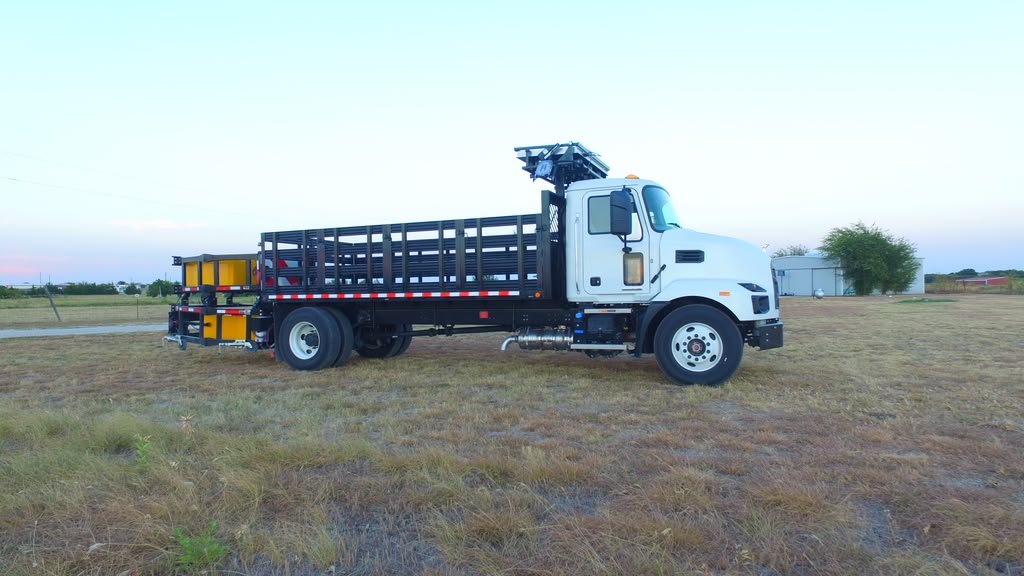 Traffic-control truck with raised arrow board at golden hour